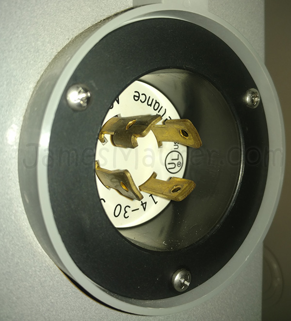 Close-up of the exterior power inlet showing the male receptacle that receives the generator cord